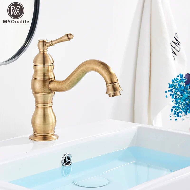 Antique brass-finished single-handle bathroom basin mixer faucet with curved spout and decorative ridged body