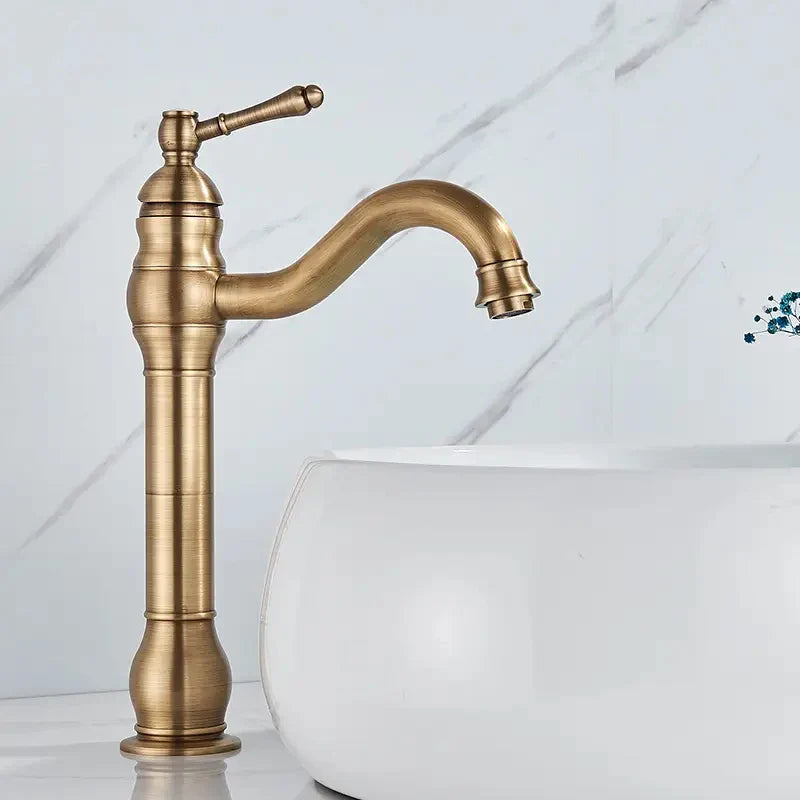 Antique brass-finished single-handle brass bathroom basin mixer faucet with curved spout and vintage design