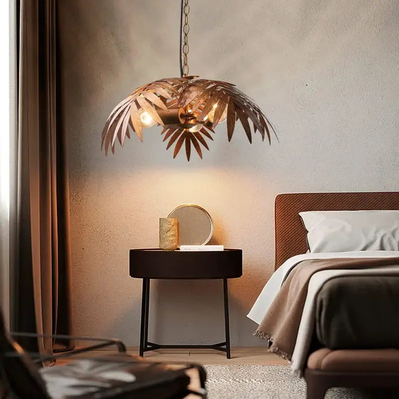 Bronze-colored brass boho coconut leaf chandelier with chain suspension and warm glowing bulbs for dining room decorbites boho coconut