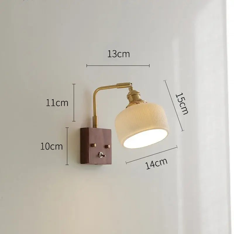 A brass ceramic ball led wall light with a yellow globe and off-white ceramic shade for living room wall lighting