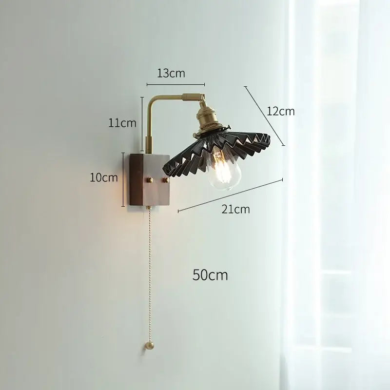 Industrial-style led wall light with brass-finished metal arm and black fan-shaped shade for living room use