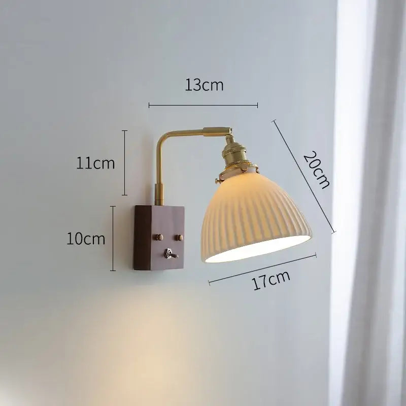 Vintage brass ceramic led wall light with off-white ribbed shade and warm yellow glow for living room use