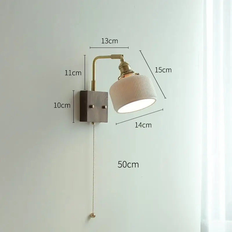 A vintage-style led wall light with brass finish and off-white ceramic shade for living room use
