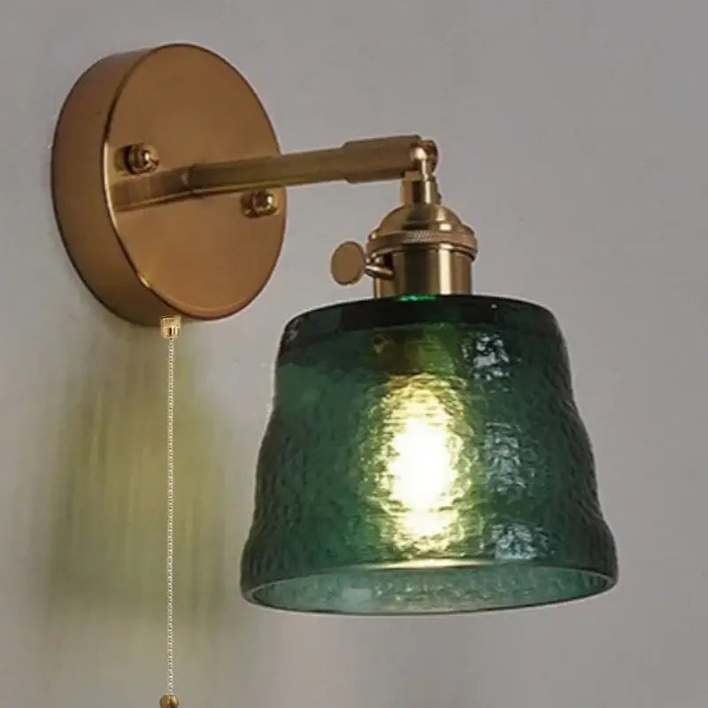 Brass clear glass led wall sconce with pull chain featuring a brass finish and textured green decorbites clear glass shade