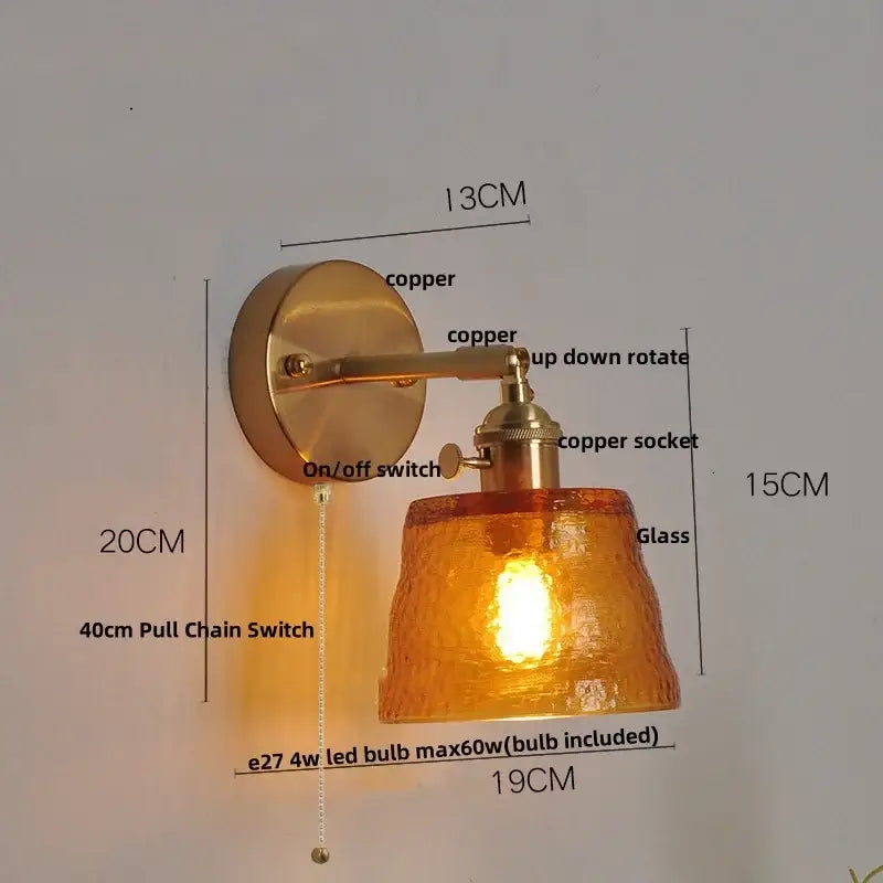 Copper-finished wall sconce with decorbites clear glass amber shade and included clear glass led bulb for bedroom lighting