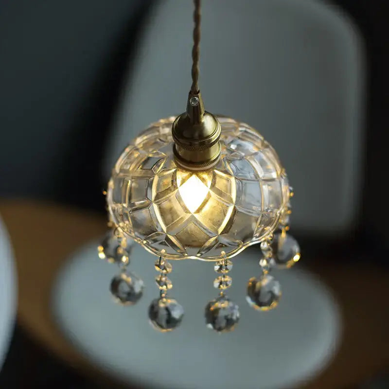 A vintage brass pendant light with a clear glass LED globe and crystal droplets for dining room decorbites
