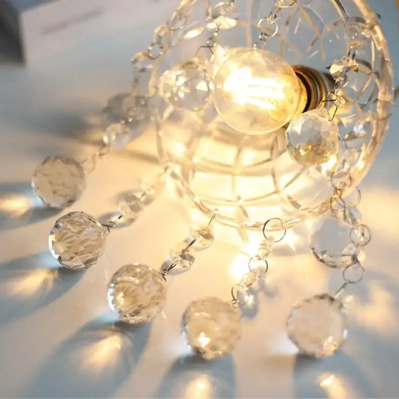 A clear crystal brass pendant light with faceted beads and warm glowing bulb for dining room decorbites clear glass led