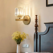 Brass-finished wall sconce with faceted decorbites crystal glass shade for elegant bedroom lighting decor