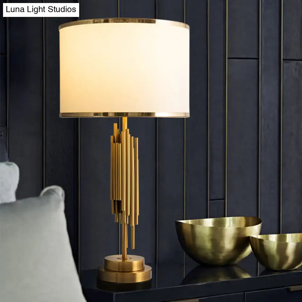 Gold-toned DecorBites brass fabric drum nightstand lamp with cylindrical white shade and vertical brass rod base for 220v-240v use