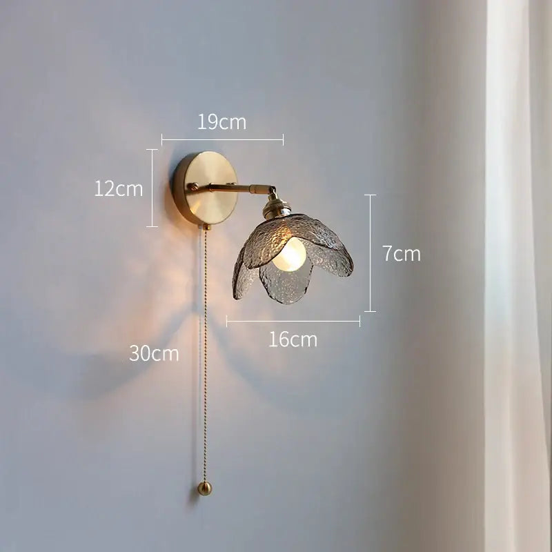A brass flower gray glass led bathroom wall lamp with a textured translucent glass shade and adjustable pull chain wall lamp