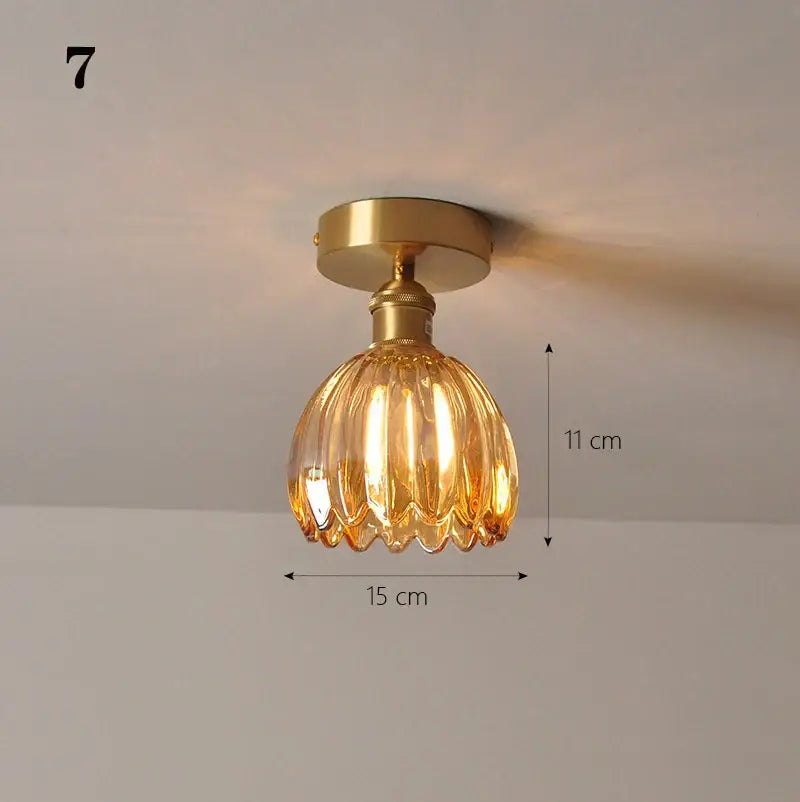A warm amber glass shade pendant ceiling lamp with brass finish and fluted ribbed design for kitchen lights