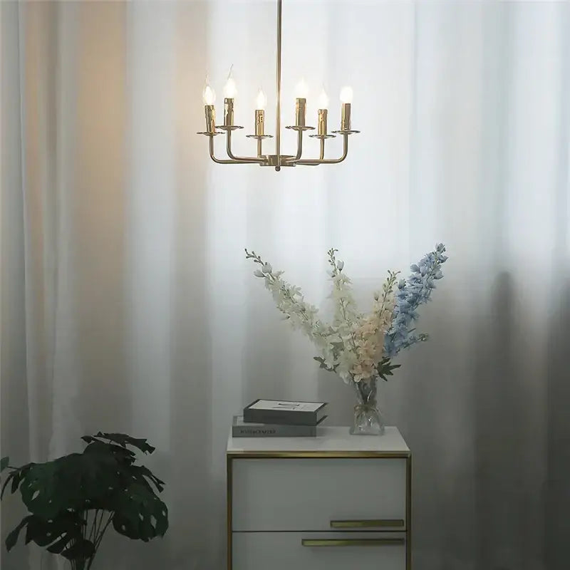 Gold-toned brass iron art chandelier lights with six candle-style bulbs for dining room decor by decorbites iron art