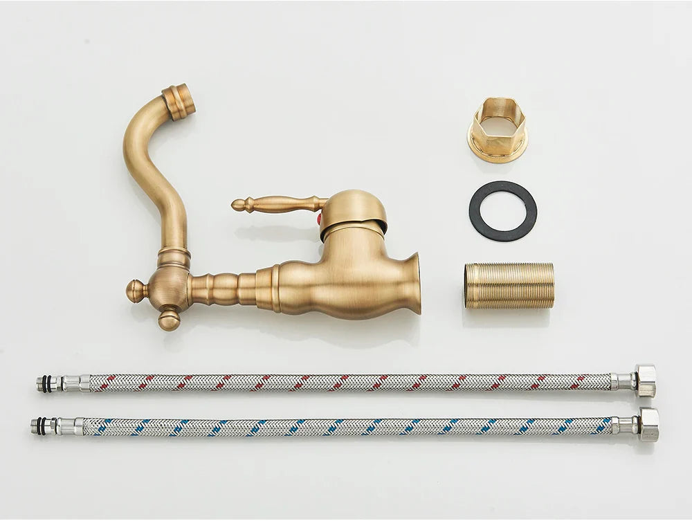 Antique brass-finished deck mounted kitchen faucet with rotating neck and ornate vintage design with matching braided hoses