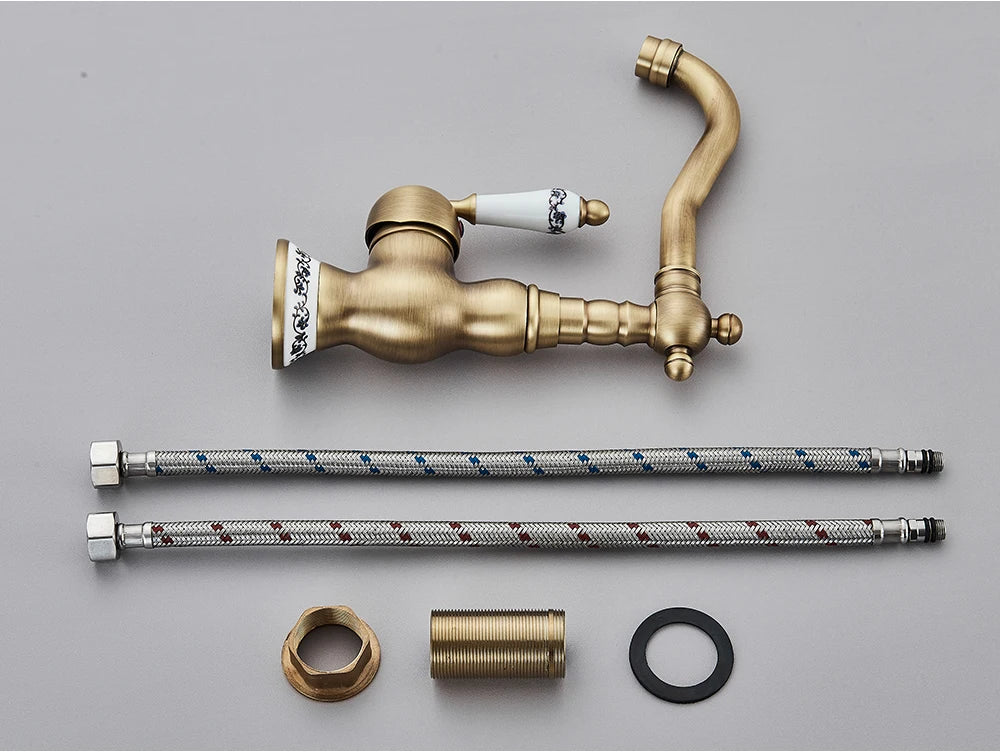 Antique brass kitchen faucet with rotating neck deck mounted featuring ceramic handle and decorative porcelain accents