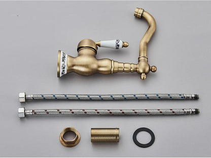 Antique brass kitchen faucet with rotating neck deck mounted featuring ceramic handle and decorative porcelain accents