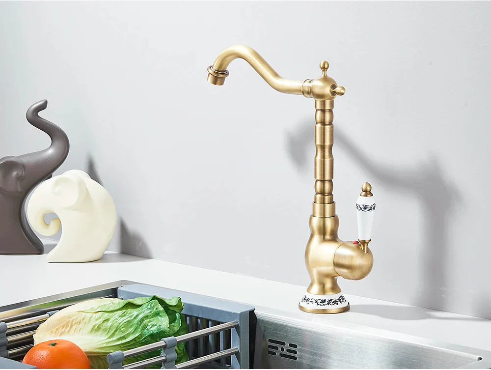 Antique brass kitchen faucet deck mounted with rotating neck ornate segmented spout and decorative porcelain handles