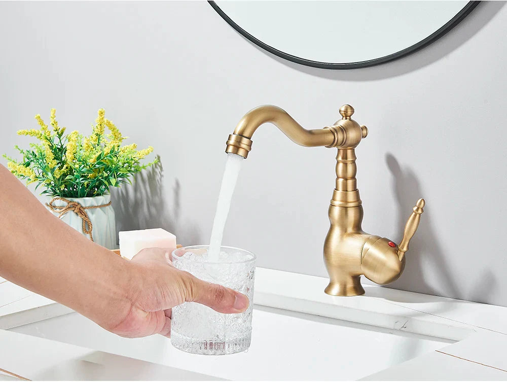 Antique brass-finished deck mounted kitchen faucet with rotating neck and ornate vintage-inspired curved spout design