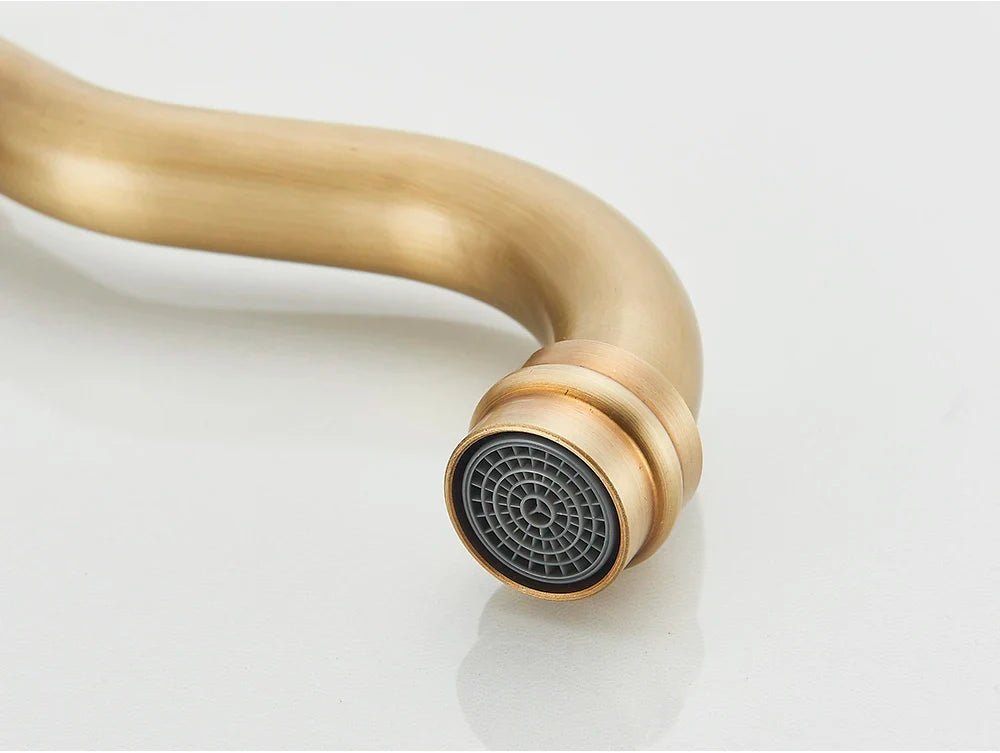 Deck mounted antique brass kitchen faucet rotating neck with curved spout and circular grid patterned nozzle