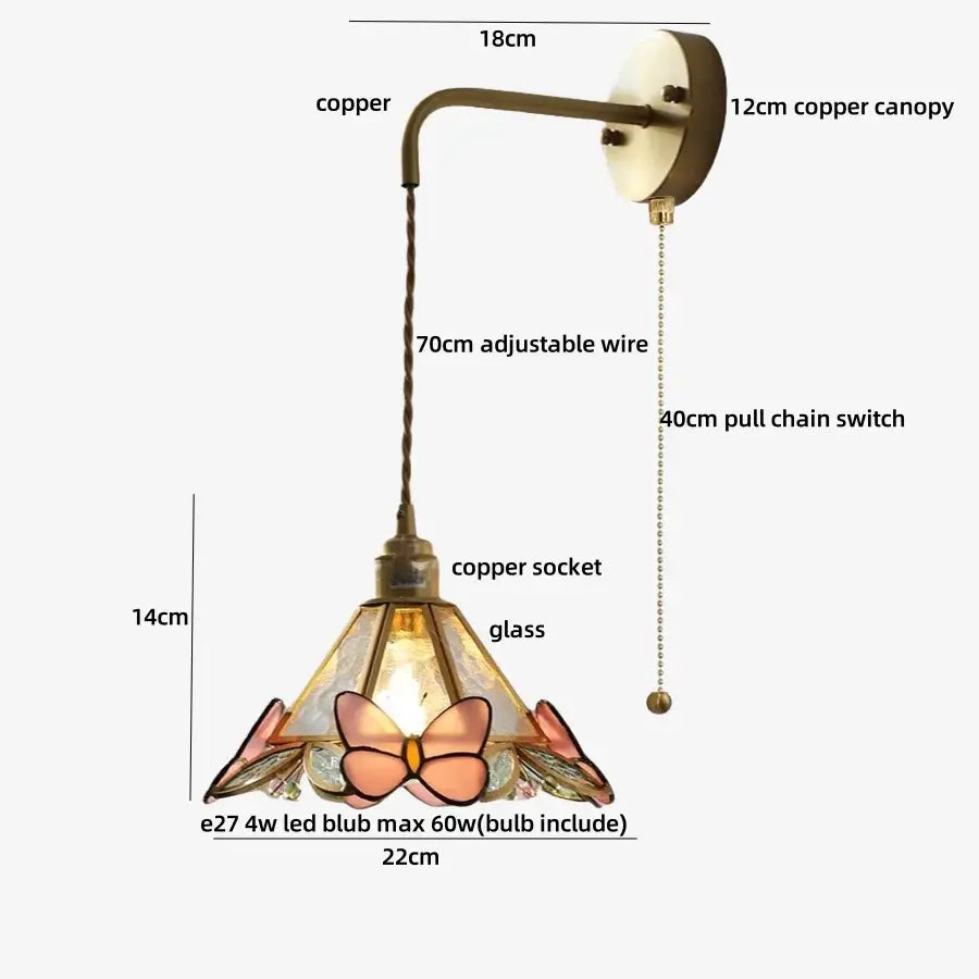 A decorative brass wall light fixture with a copper base and stained glass shade featuring pink and peach butterfly motifs