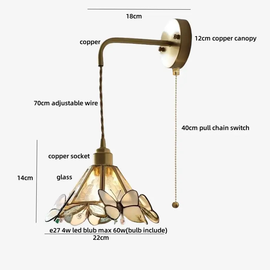 Antique brass wall light fixture with orange butterfly stained glass shade featuring amber tinted panels for bedroom use
