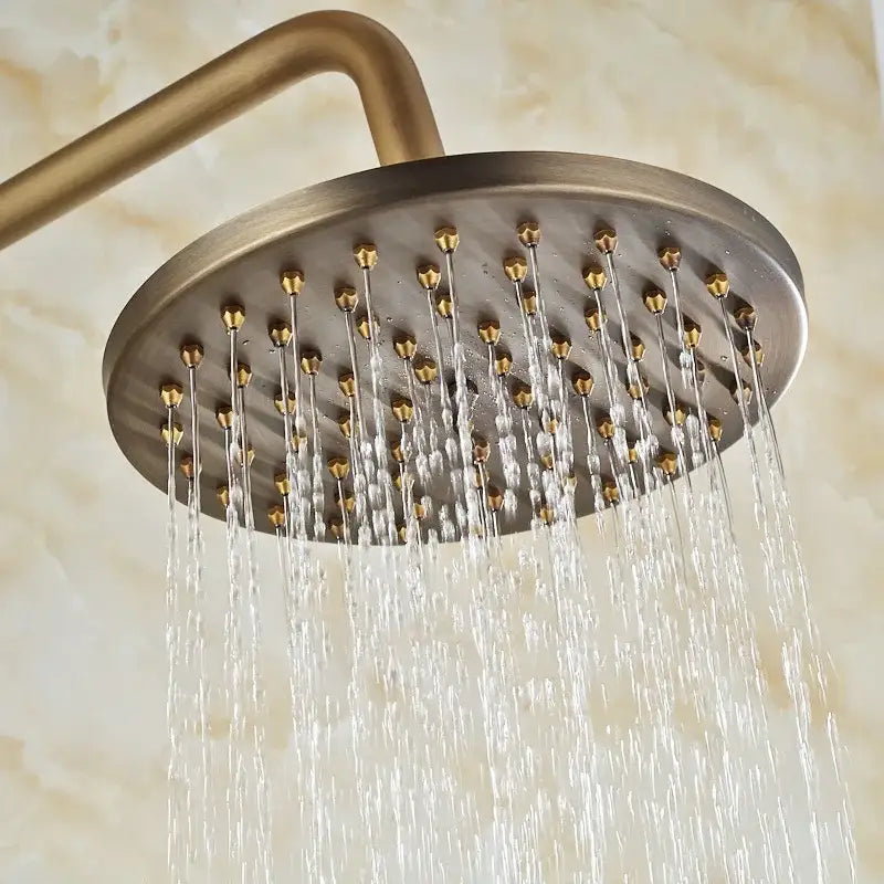 Antique brass round rainfall shower faucet with multiple jets and matching curved arm for bathroom use