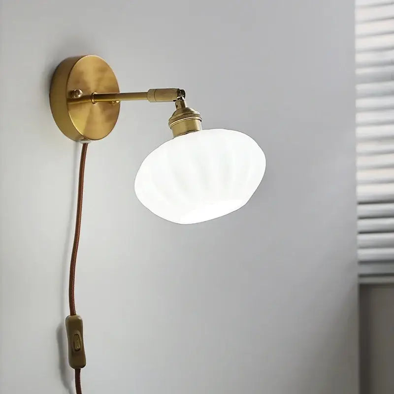 Vintage-style brass led wall sconce with white ribbed ceramic led shade and brown cord for bedroom mirror lighting decorbites ceramic led