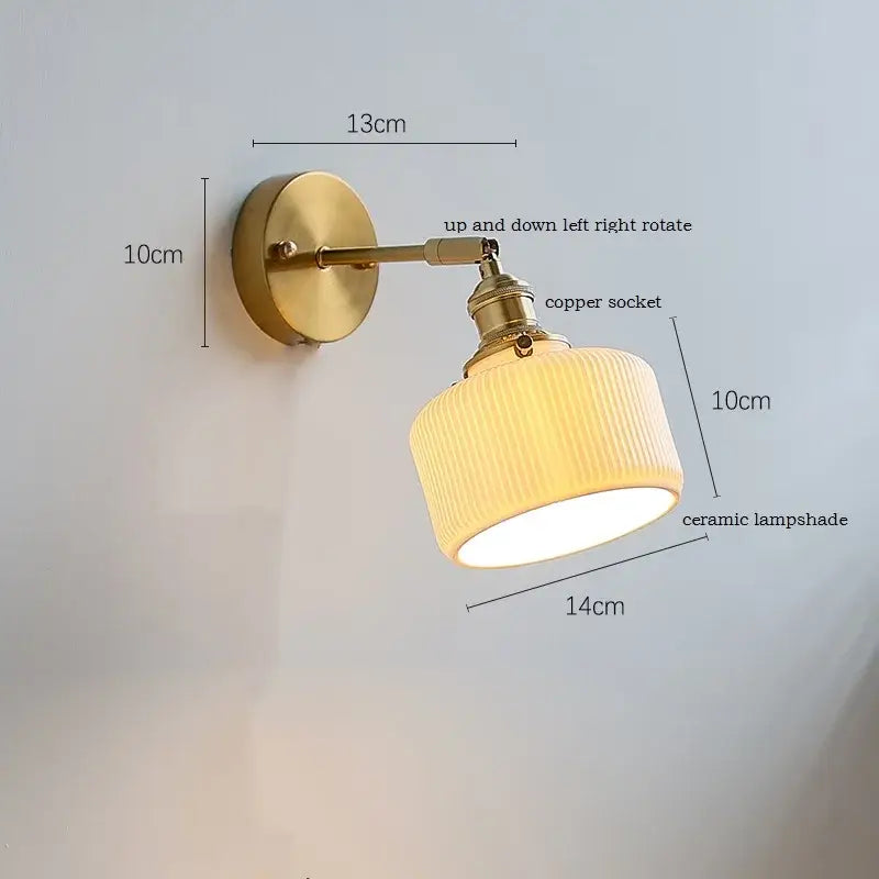 Brass ribbed decorbites ceramic wall sconce with iron arm features a warm-toned ceramic lampshade for bedroom lighting