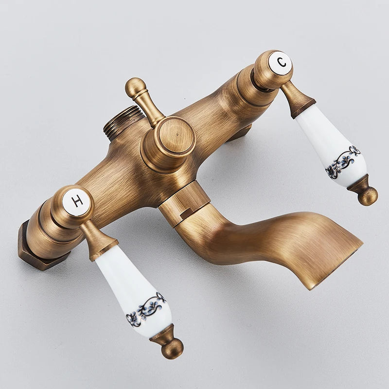 Antique brass-finished wall mount shower faucet with white ceramic handles labeled h and c for hot and cold water