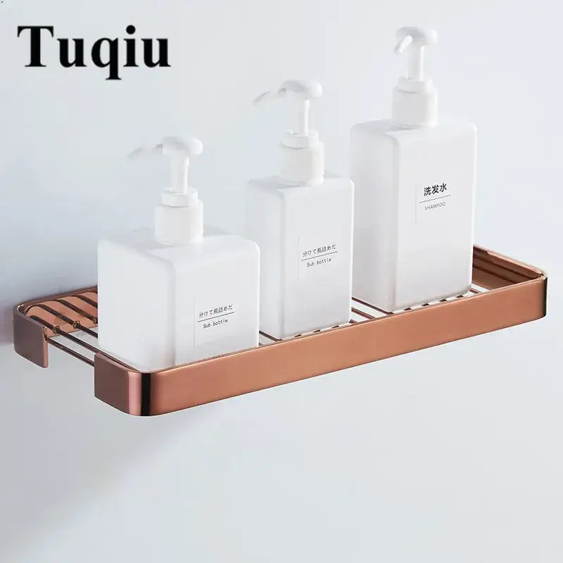 Copper-toned brass square bathroom wall-mounted slatted metal shelf holding three white pump bottles for shower decorbites brass square