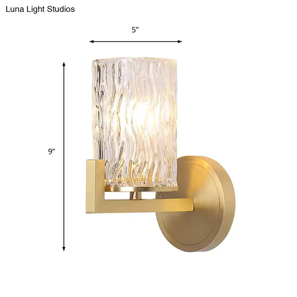 Gold-finished brass wall light with cylinder rippled glass and textured translucent cylinder for bedroom sconce use