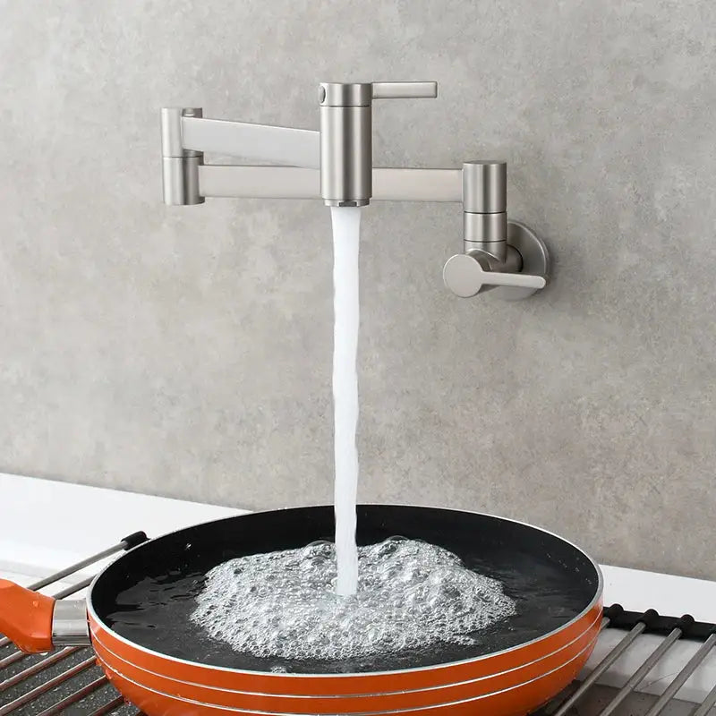 Brass wall mounted pot filler kitchen faucet with brushed stainless steel finish and articulated gooseneck pouring water