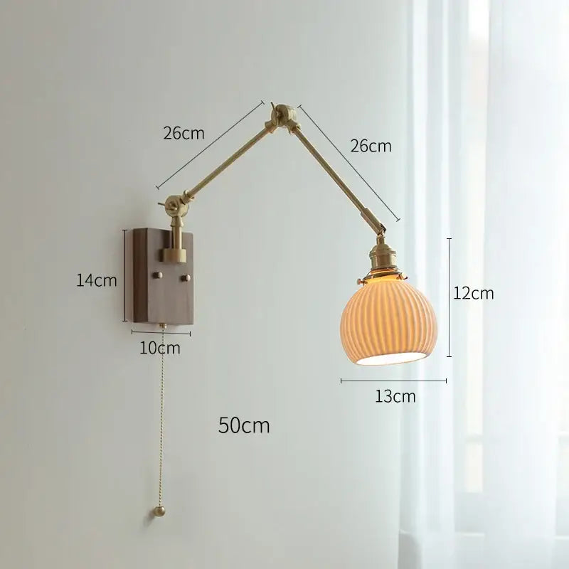 Brass-finished wall sconce with copper swing arm and ribbed amber glass shade for bedroom lighting
