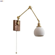 Brass walnut wall light with adjustable brass finish, white ribbed glass shade, and wooden mounting plate for bedroom decor