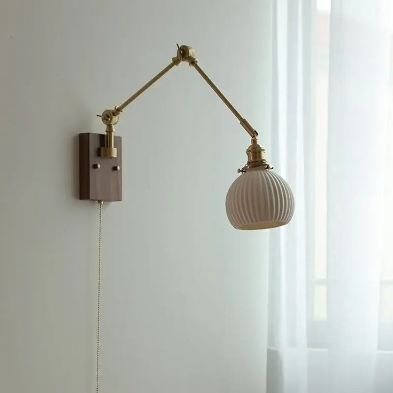 Brass walnut wall light with a cream ribbed glass shade and brass articulated arm for bedroom decorbites ceramic ball design