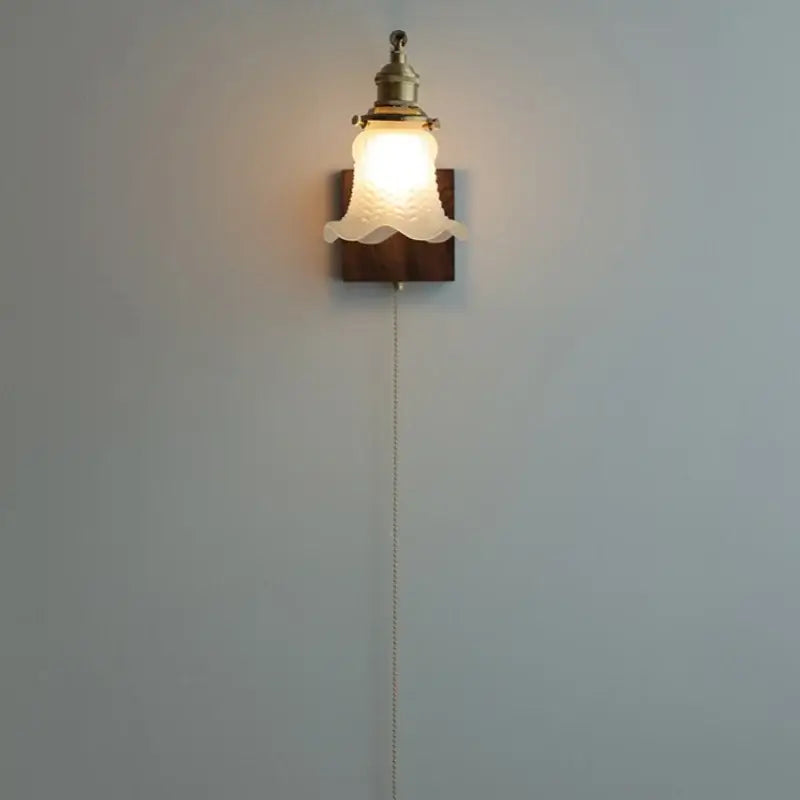 Brass walnut wood wall sconce with brass-finished metal and off-white textured glass shade on dark wood plate decorbites brass walnut