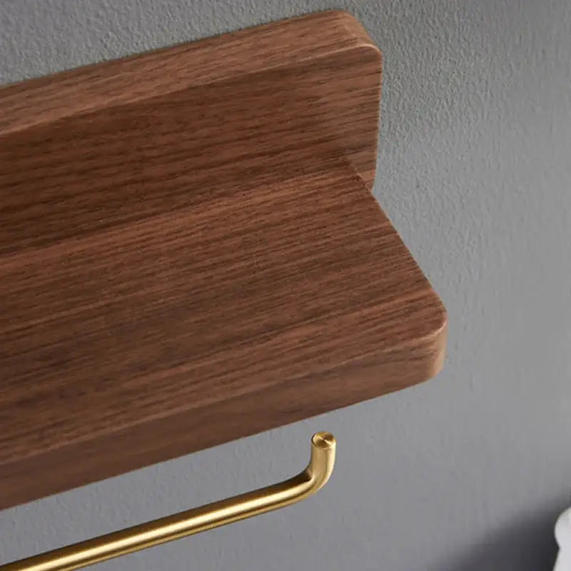 Brass and wood toilet roll holder stand with a sleek dark brown wooden shelf and polished gold-toned metal holder beneath