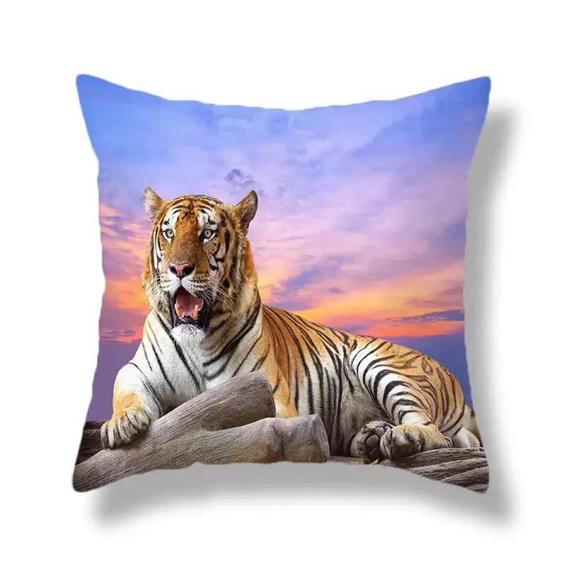Square throw pillow with brave tiger pattern print in orange and black resting against a purple sunset sky