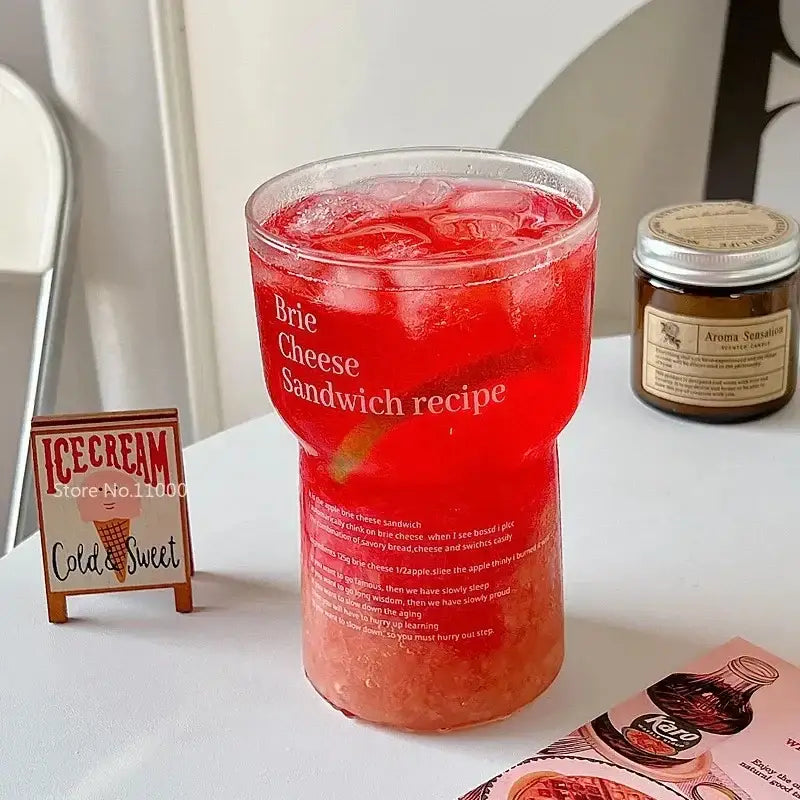 Brie cheese sandwich printed clear glass coffee mug filled with red iced drink and white text with straw