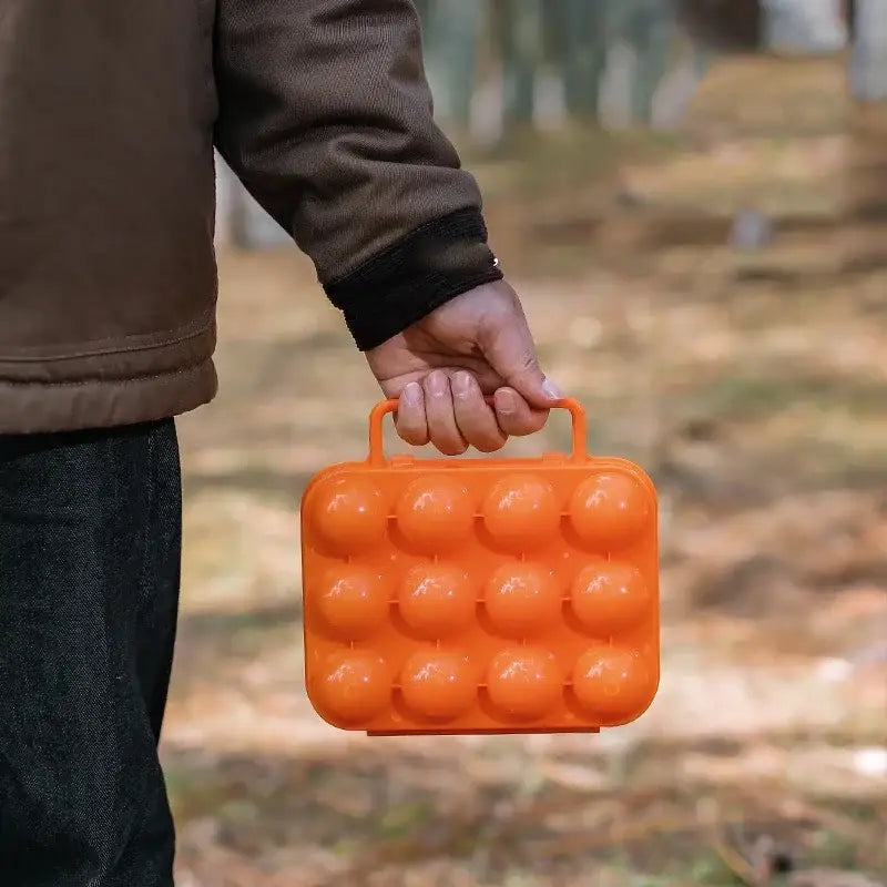 Bright orange plastic egg holder storage box with 12 round compartments and top handle for kitchen use