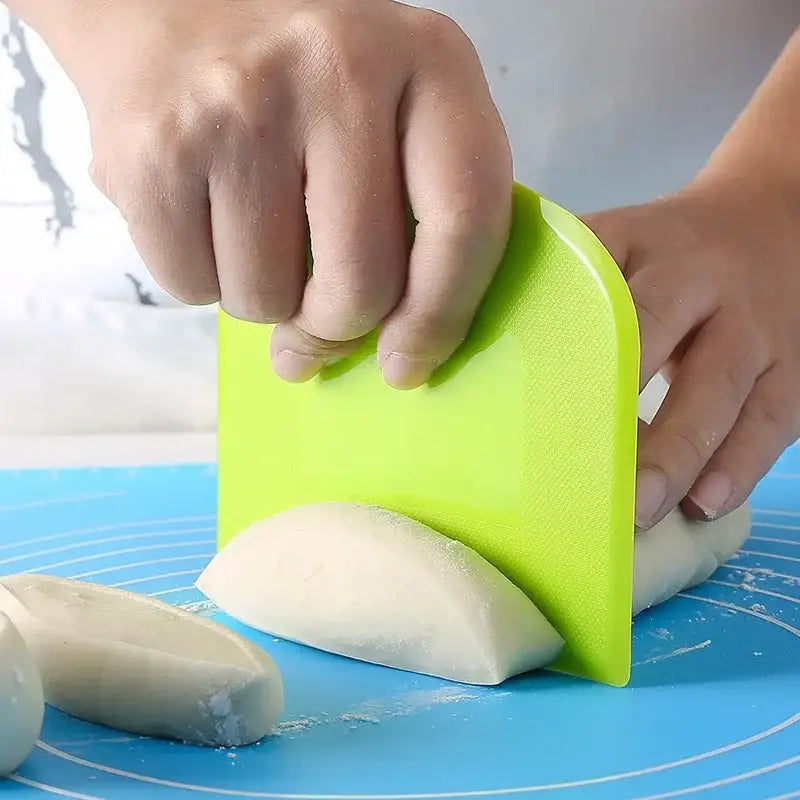 Bright green silicone spatula dough cutter used to portion white dough for baking decorbites cake spatula