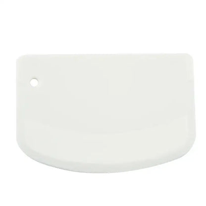 White silicone pastry scraper with rounded edge and hanging hole used as a spatula dough cutter decorbites cake spatula