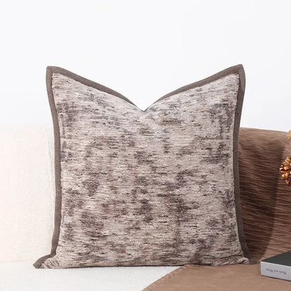 Square-shaped brighton cross stitch cushion cover with textured gray beige fabric and dark brown woven leather border for living room