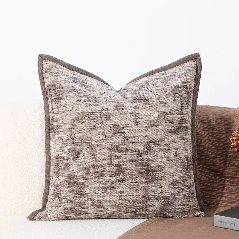 Square-shaped brighton cross stitch cushion cover with textured gray beige fabric and dark brown woven leather border for living room