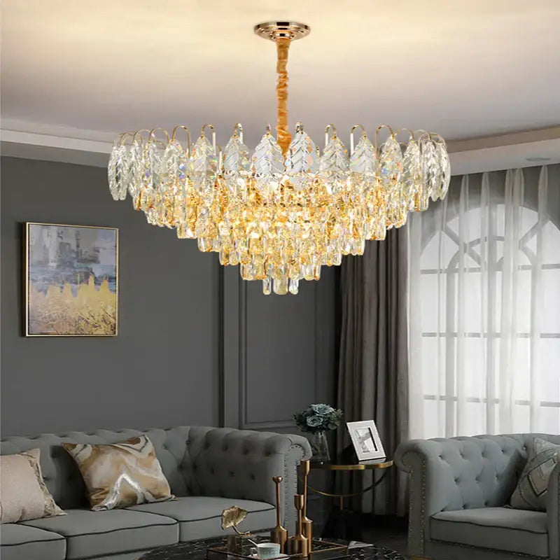 Golden-toned decorbites brilliance crystal chandelier with cascading amber and clear glass prisms in polished brass rose gold fixture
