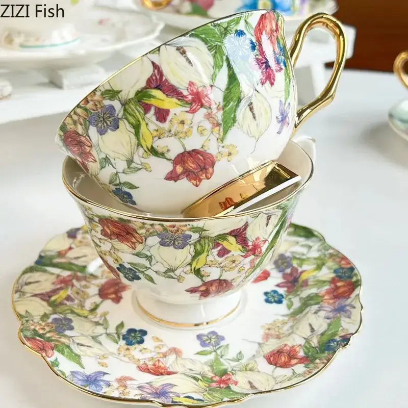A delicate porcelain teacup and saucer set with brilliant flowers pattern in red purple blue and green with gold trim