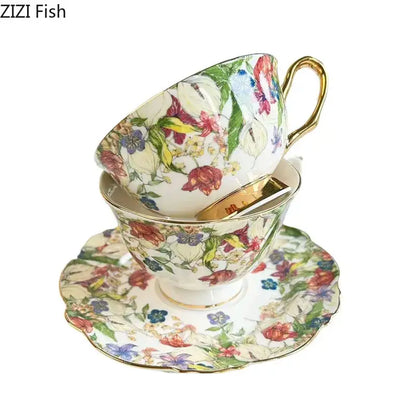 A porcelain teacup and saucer dining room set with a brilliant flowers pattern in red pink blue and green with gold trim
