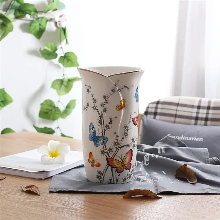 A white bird butterfly porcelain vase with colorful butterfly and branch illustrations and a gold-trimmed rim for decorbites decorbites bird butterfly