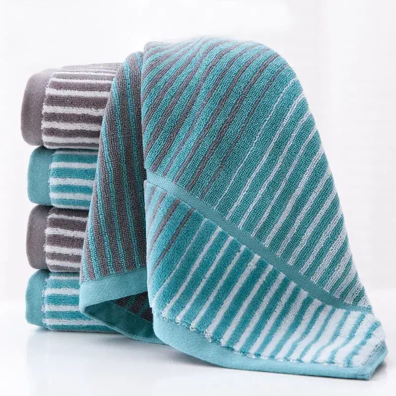 A soft plush turquoise and gray striped sports fitness towel with textured weave for gym accessory use