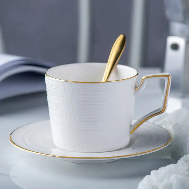 White ceramic coffee cup with gold trim and textured pattern on matching saucer from british white tea set decorbites bone porcelain