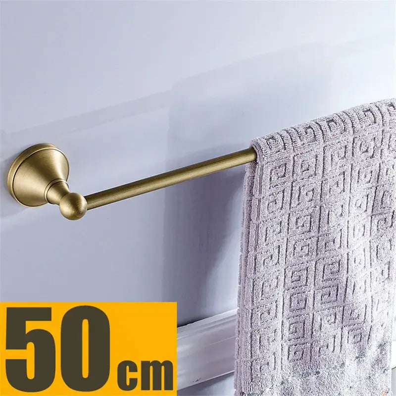 Bronze and white ceramic bathroom accessories set with a 50cm brass-finished towel rack and geometric patterned towel for decorbites bronze bathroom